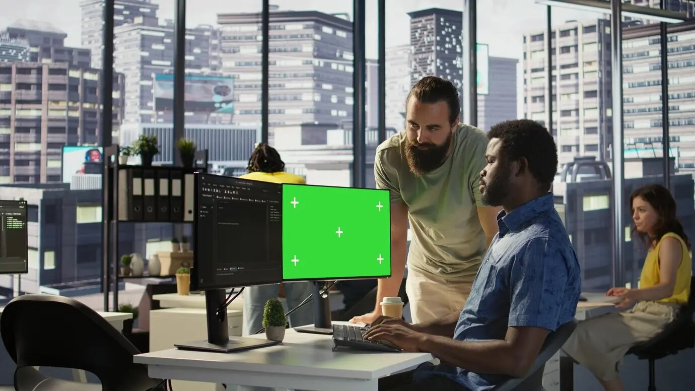 Team von IT-Mitarbeitern, das einen Computer mit grünem Bildschirm verwendet